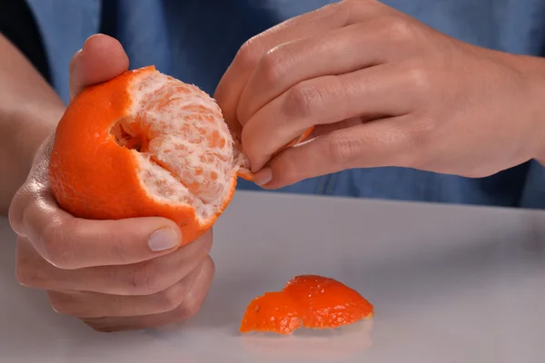 Mulher descascando tangerina fruta . — Fotografia de Stock