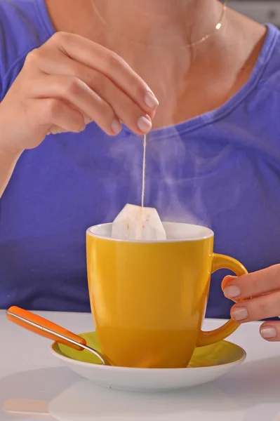 Mujer empapando la bolsa de té — Foto de Stock