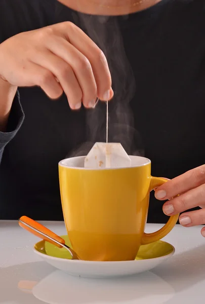 Mujer empapando la bolsa de té en taza —  Fotos de Stock