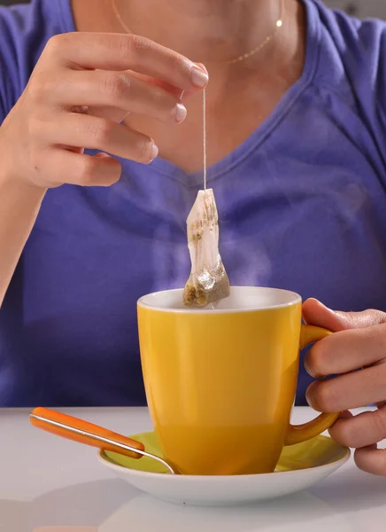 Mujer empapando la bolsa de té en taza — Foto de Stock