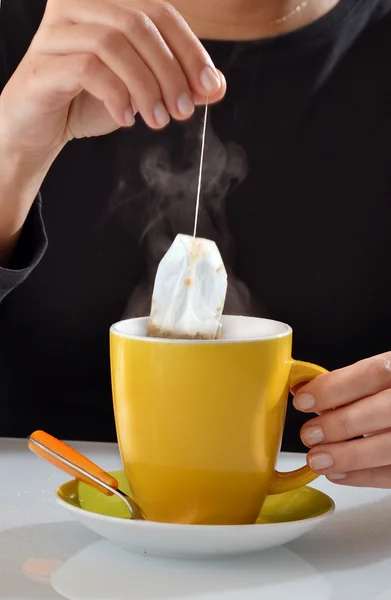 Mujer empapando la bolsa de té en taza —  Fotos de Stock