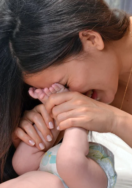 母彼女の赤ちゃんの足にキス. — ストック写真