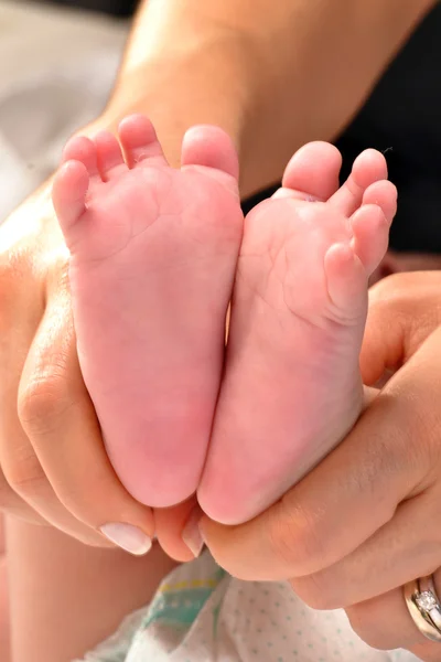 Moeder greep voeten van pasgeboren — Stockfoto