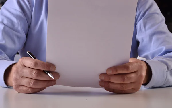 Empresario sosteniendo y leyendo documento — Foto de Stock