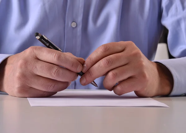 Człowiek posiadający pióro do podpisania dokumentu — Zdjęcie stockowe