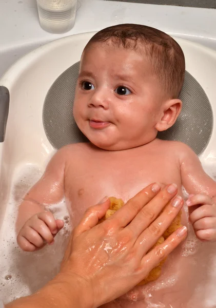 Mamma tvätt baby i badkar — Stockfoto