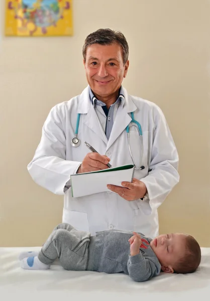 Pediatra examinando a un niño . — Foto de Stock