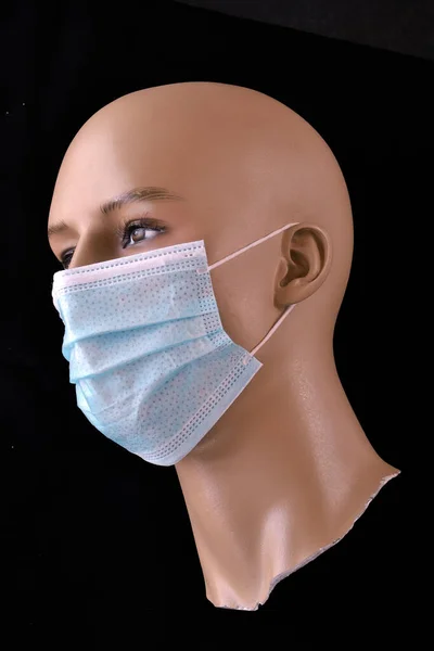 黒の背景に隔離されたマネキンの頭部の医療保護マスク — ストック写真