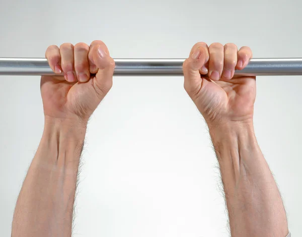 Hands hanging a metallic bar — Stock Photo, Image