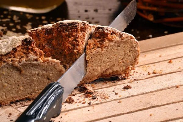 Slicing rustic bread — Stock Photo, Image