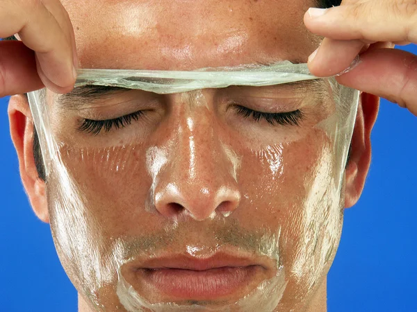 Hombre quitándose la máscara facial —  Fotos de Stock