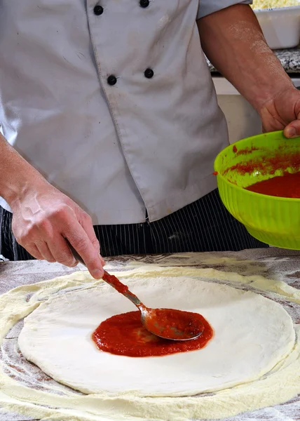 Cook adding tomato saucev — Stock Photo, Image