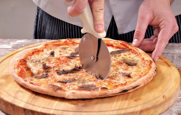 Cutting anchovy pizza — Stock Photo, Image