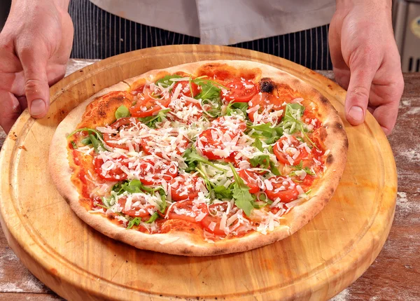 Cuisinier tenant une tranche de pizza . — Photo