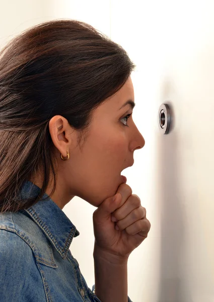 Woman looking out through the peephole — Stock Photo, Image