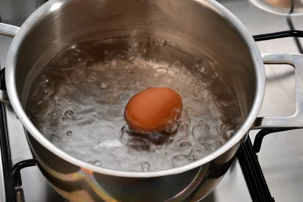 Boiling egg in saucepan — Stock Photo, Image