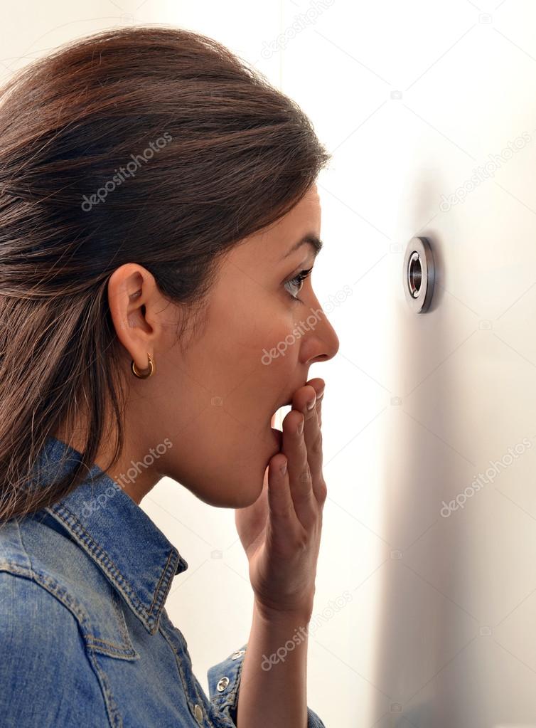 Woman looking out through the peephole