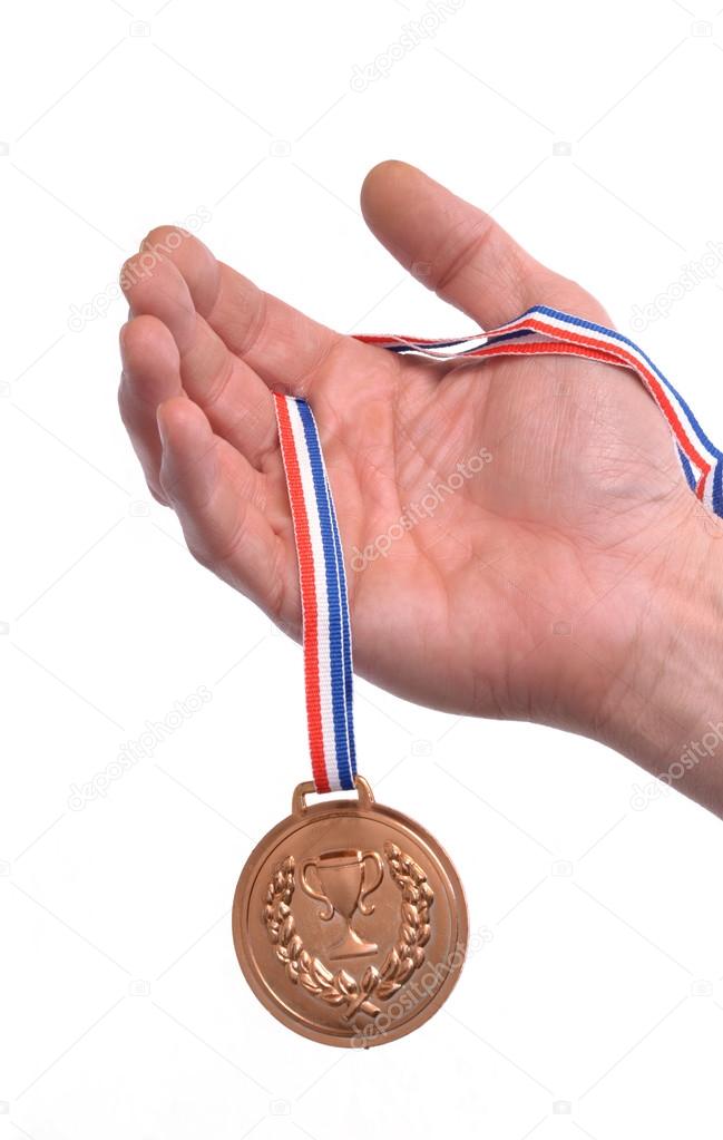 Hand holding gold medal