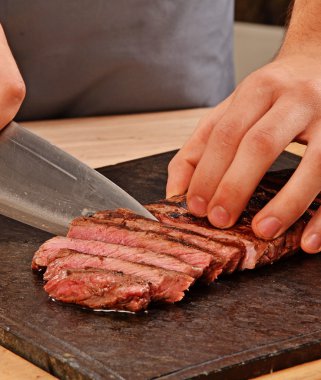 Cook slicing grilled beef