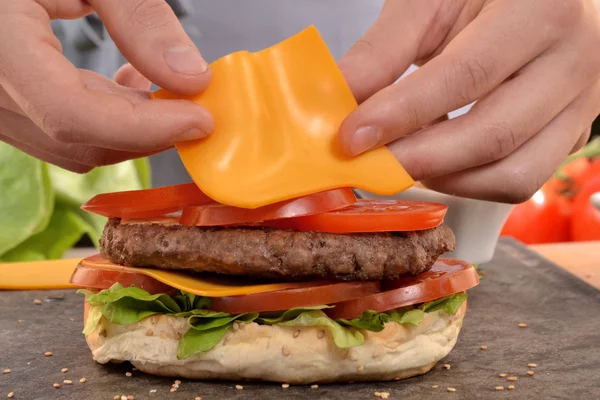 Hands holding and preparing hamburger. — Stock Photo, Image