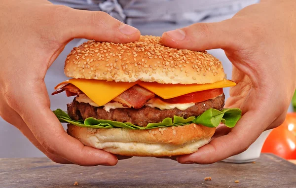 Cucinare le mani tenendo hamburger — Foto Stock