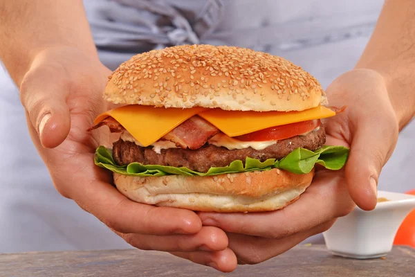 Cook hands holding  hamburger — Stock Photo, Image