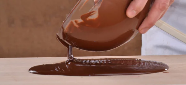 Homem derramando chocolate escuro derretido — Fotografia de Stock