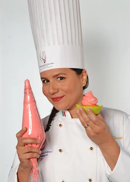 Femme cuisinier tenant cupcake crémeux — Photo