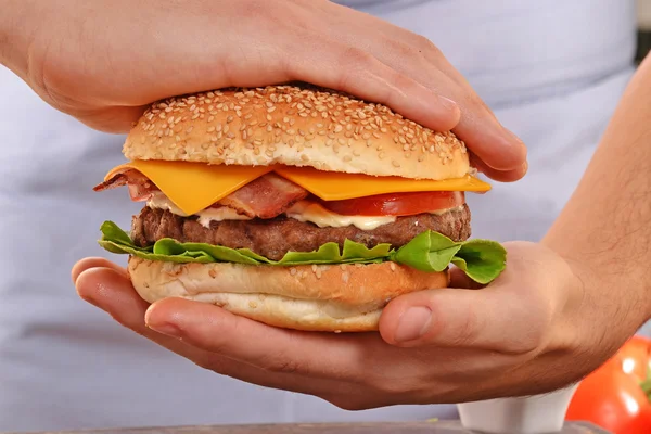 Cook hands holding  hamburger — Stock Photo, Image