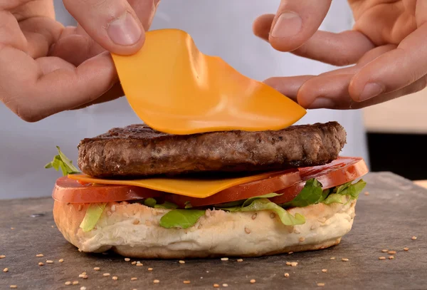 Hands holding and preparing hamburger. — Stock Photo, Image