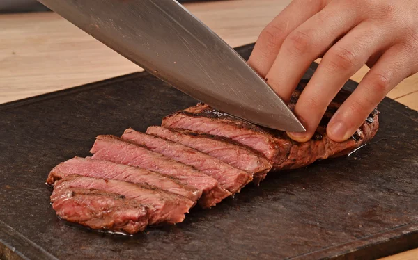 Cook slicing grilled beef — Stockfoto