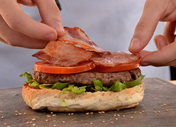 Hands holding and preparing hamburger. — Φωτογραφία Αρχείου