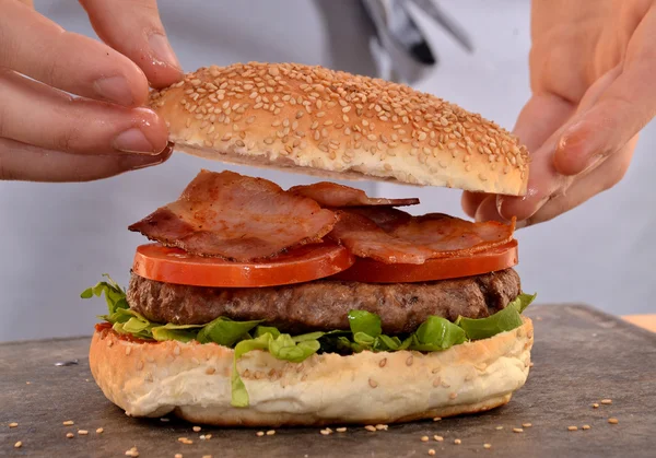 Hands holding and preparing hamburger. — Stockfoto