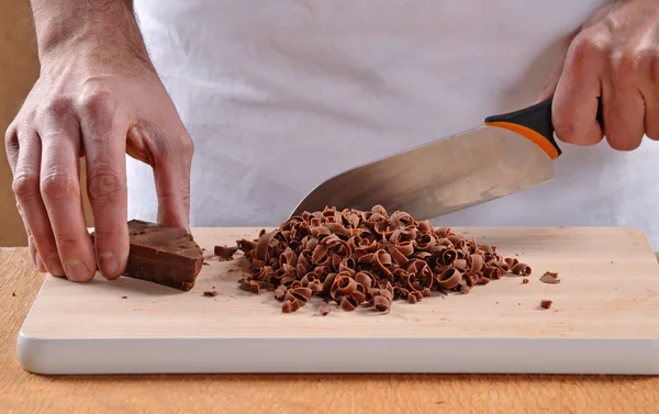 Les mains tranchant du chocolat frais — Photo