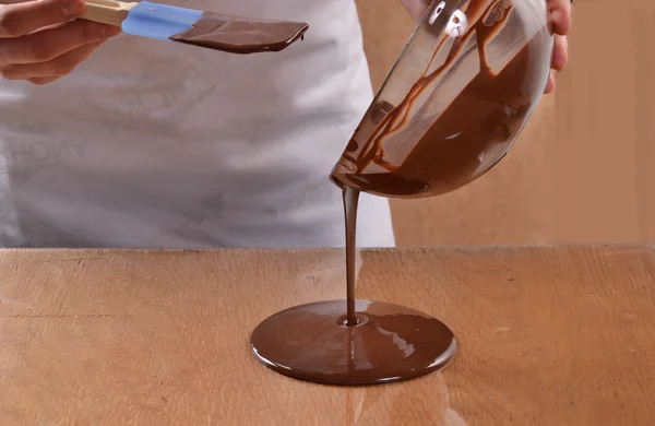 Homem derramando chocolate escuro derretido — Fotografia de Stock