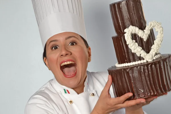 Woman holding a big chocolate cake. — Stock Photo, Image