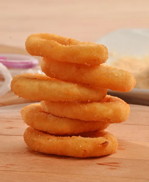 Onion rings on wood table Stok Resim