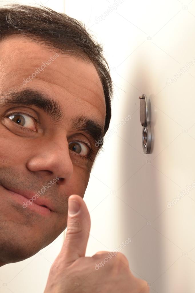 Man looking out through peephole
