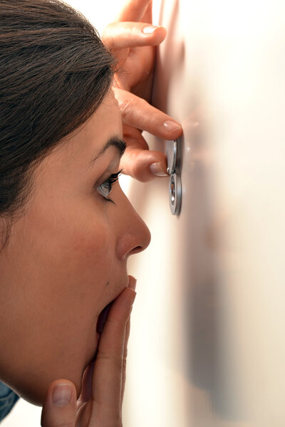 Woman looking out through the peephole