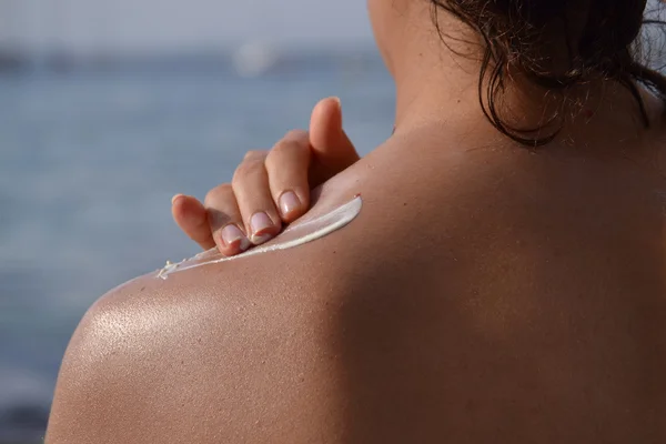 Femme appliquant protection crème solaire pour le corps — Photo