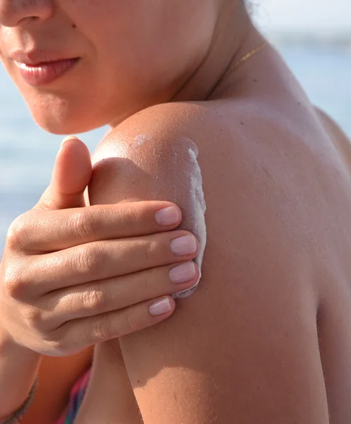 Donna che applica protezione crema corpo sole — Foto Stock
