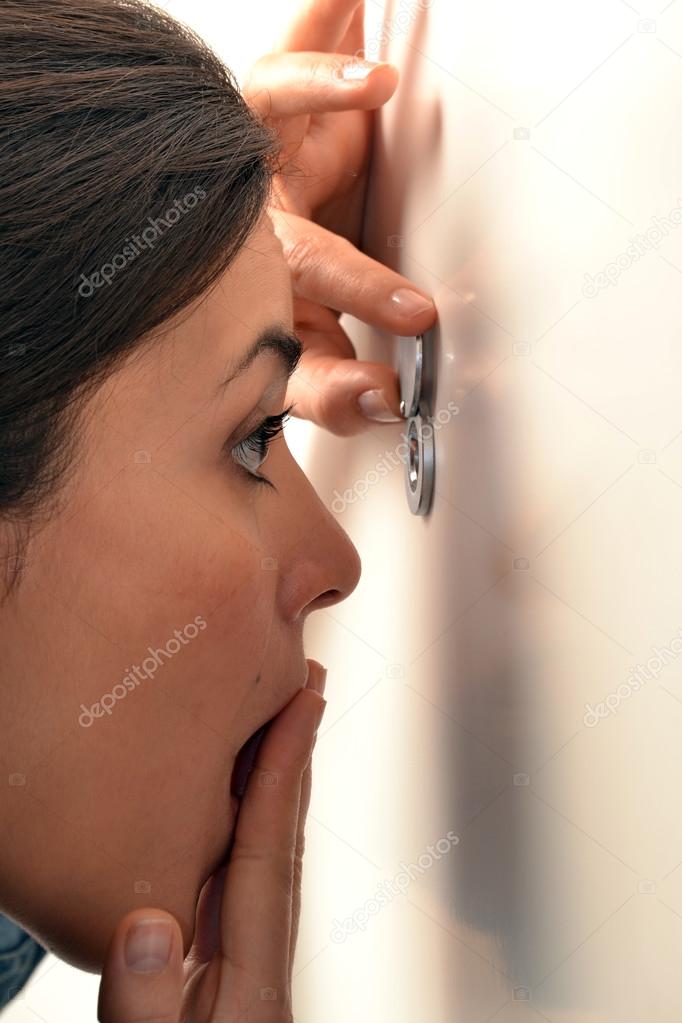 Woman looking out through the peephole