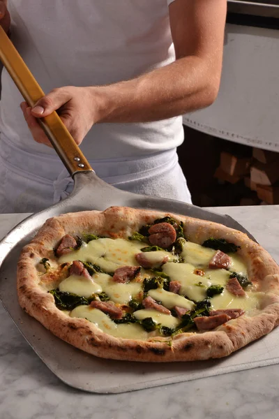 Cook gebakken pizza nemend — Stockfoto