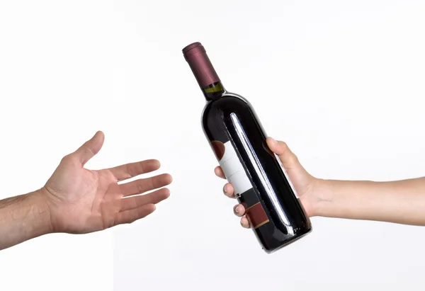 Hand giving red wine bottle — Stock Photo, Image