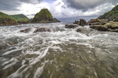 Dalga güçlü su ve bulutlu gün batımı arka plan Pantai Semeti Lombok, Indonesi, doğal taşla