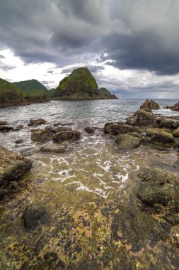 Dalga güçlü su ve bulutlu gün batımı arka plan Pantai Semeti Lombok, Indonesi, doğal taşla