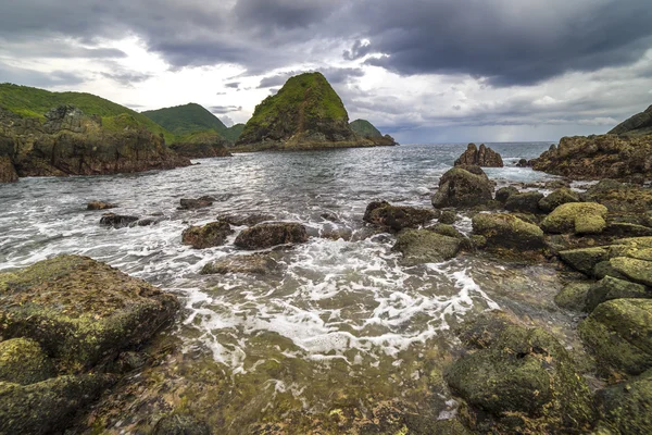 Dalga güçlü su ve bulutlu gün batımı arka plan Pantai Semeti Lombok, Indonesi, doğal taşla