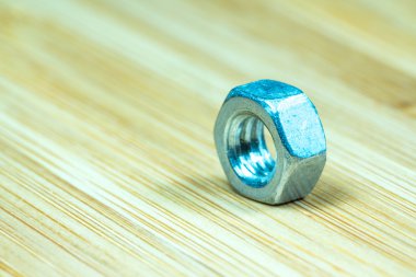 Bambu doku yüzeyi arka planında somunlar ve cıvatalar yakın çekim