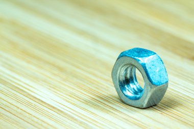 Bambu doku yüzeyi arka planında somunlar ve cıvatalar yakın çekim