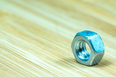 Bambu doku yüzeyi arka planında somunlar ve cıvatalar yakın çekim